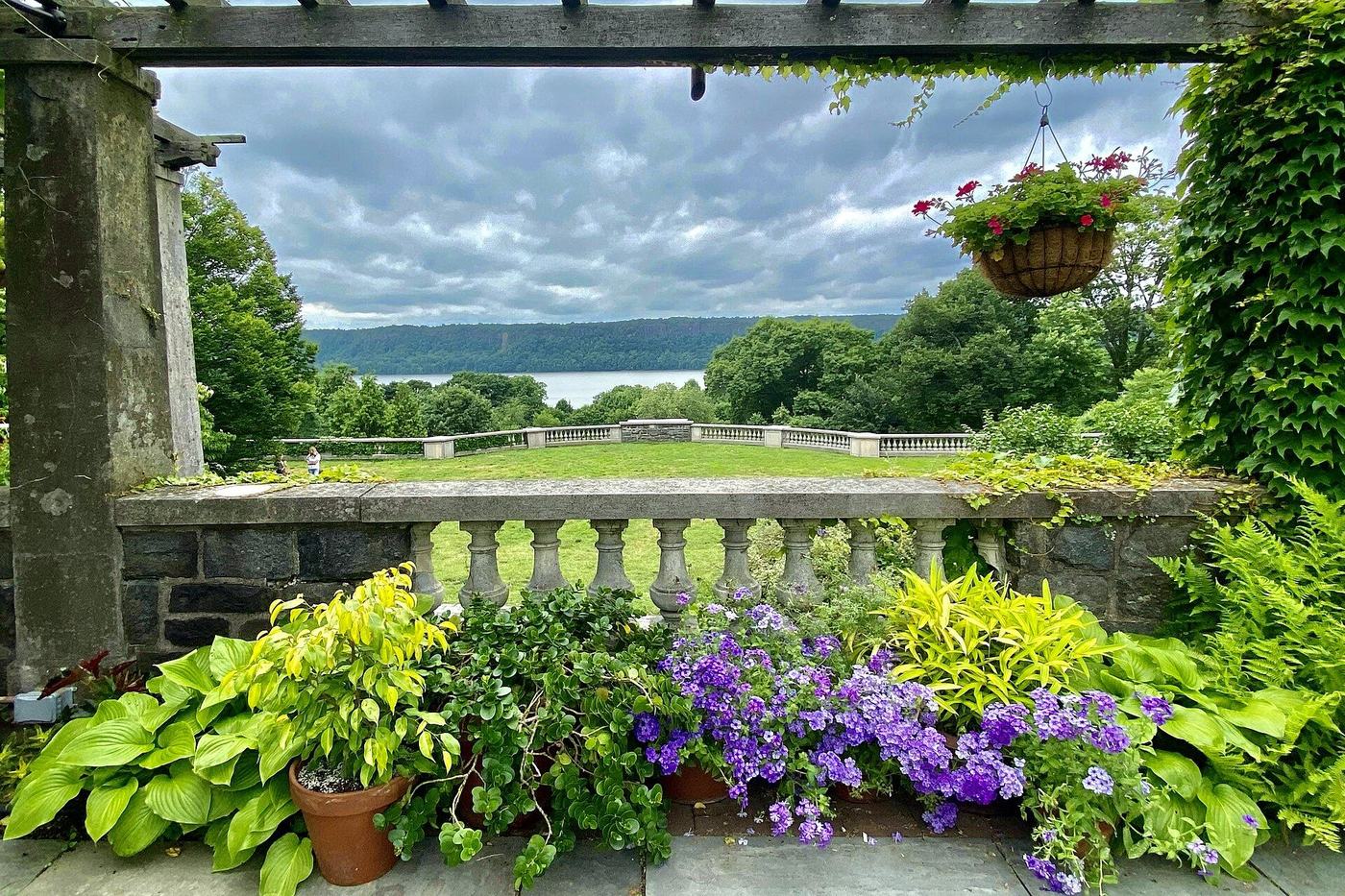 Utsikt mot Hudson River og Palisades fra en pergola med søyler og tak i Wave Hill i New York.